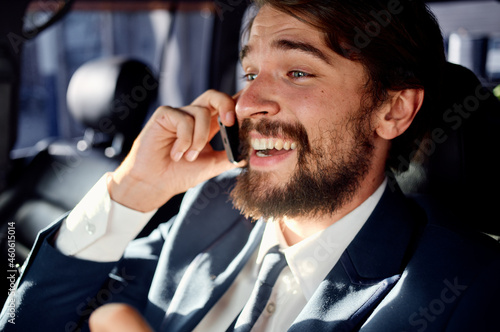 business man with a beard talking on the phone in a car trip