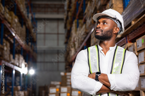 Portrait of Confident Male worker standing with arms crossed wearing uniform in a distribution warehouse. Retail  Logistic  delivery people.