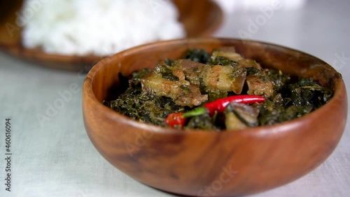 Laing is a Filipino dish of shredded or whole taro leaves with meat or seafood cooked in thick coconut milk spiced with labuyo chili, lemongrass, garlic, shallots, ginger, and shrimp paste photo