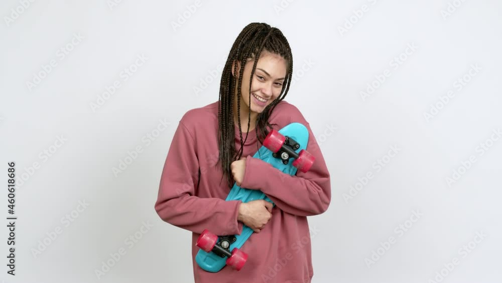Teenager girl with braids holding roller skates over isolated background Teenager girl with braids holding roller skates over isolated background