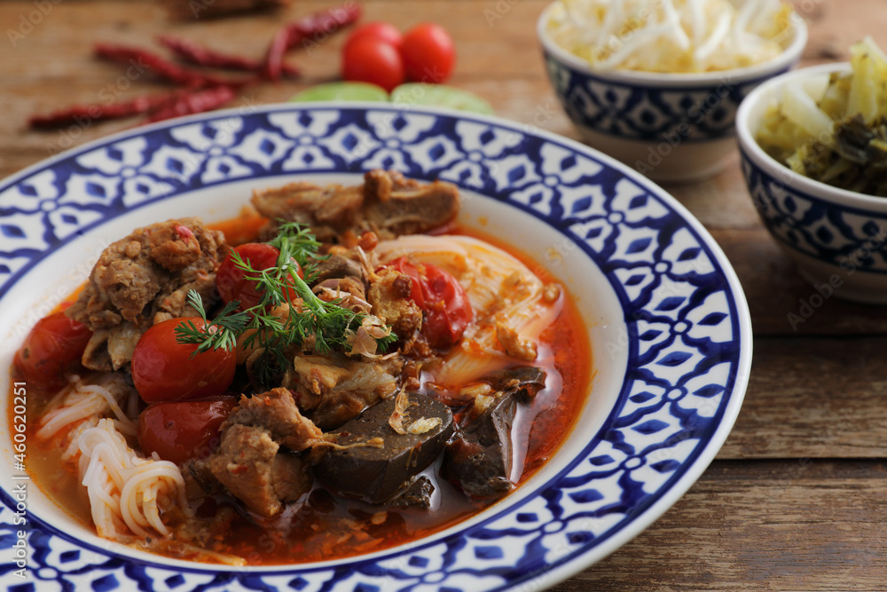 Local northern thai food Rice noodles with pork in spicy soup in wood background Local northern thai food Rice noodles with pork in spicy soup in wood background