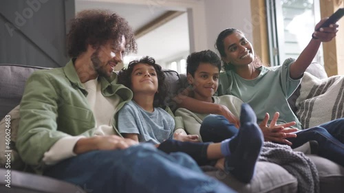 Slow motion of happy family watching tv on sofa