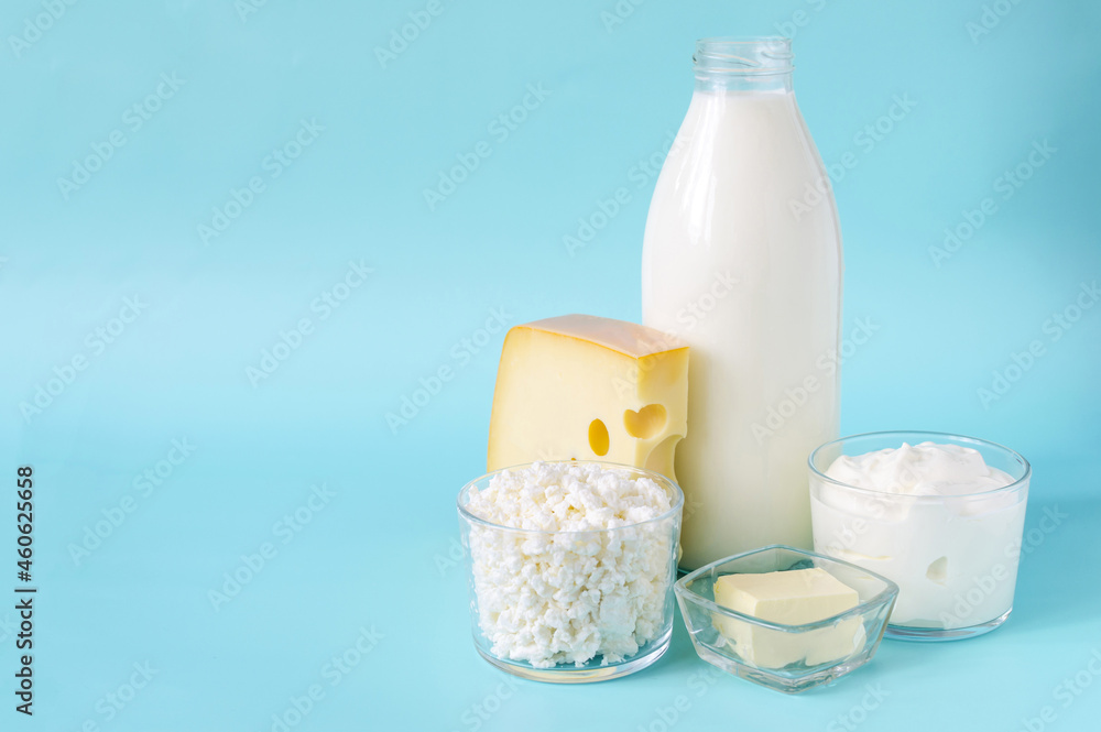Milk products close-up on a blue background is a place for advertising. Milk, kefir, sour cream, cheese, butter and cottage cheese in a glass container on a light background Milk products close-up on a blue background is a place for advertising. Milk, kefir, sour cream, cheese, butter and cottage cheese in a glass container on a light background