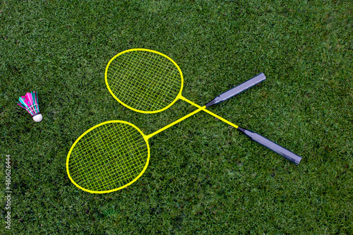bright badminton rackets and a shuttlecock on the green grass