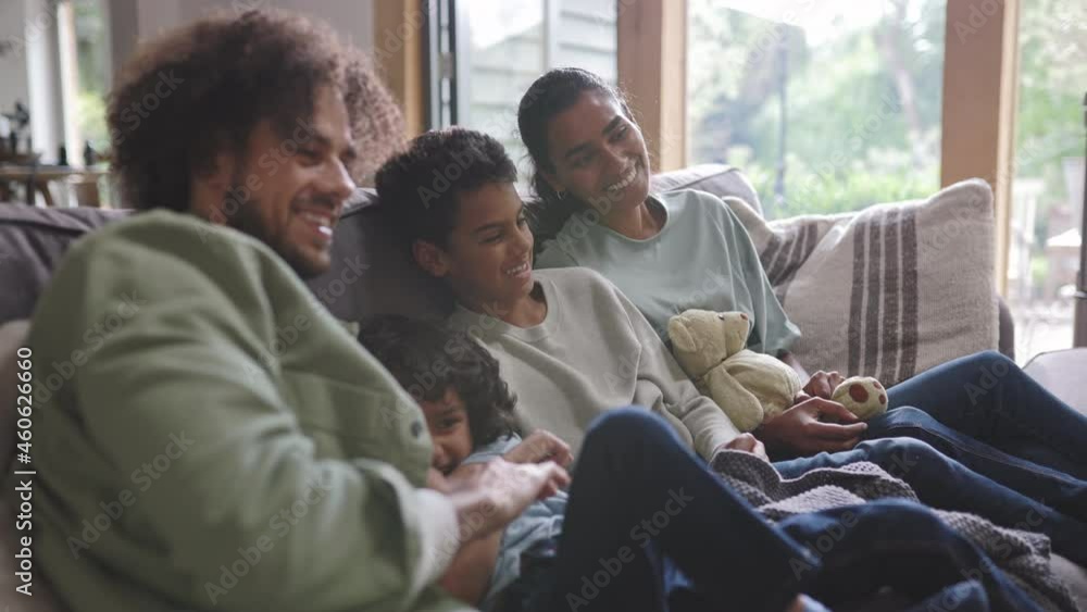 Slow motion of happy family watching tv on sofa Slow motion of happy family watching tv on sofa