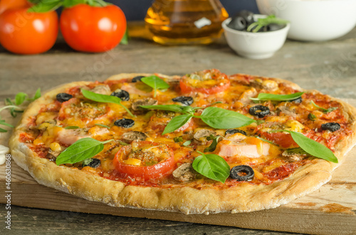 Delicious fresh homemade pizza with ham on wooden background with selective focus