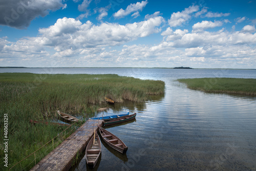 Wooden boats on the lake at the pier among the reeds. View from above.