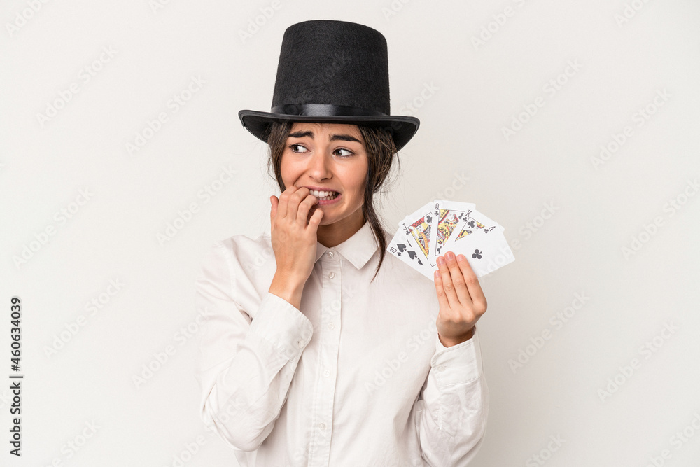 Naklejka premium Young magician woman holding a wand isolated on white background biting fingernails, nervous and very anxious.