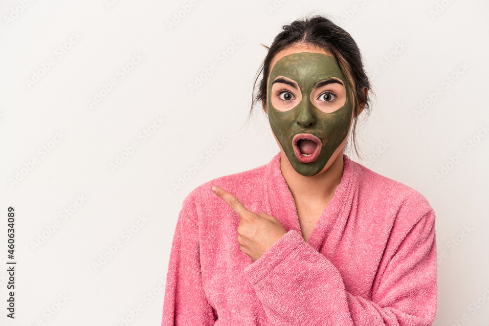 Young caucasian woman wearing a facial mask isolated on white background pointing to the side Young caucasian woman wearing a facial mask isolated on white background pointing to the side