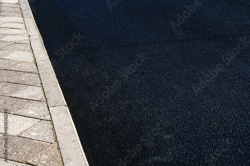 A fragment of an asphalt road and a pedestrian sidewalk. Copy space