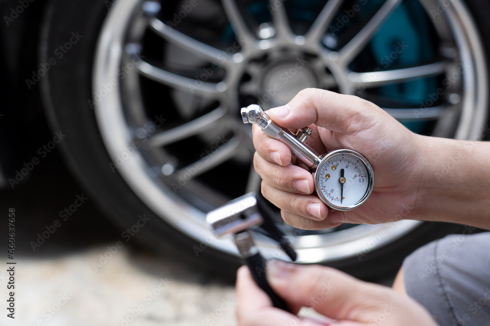 Fototapeta premium Home car basic check : A man use air pressure gauge check tire air pressure and hole air hose for add air of tire