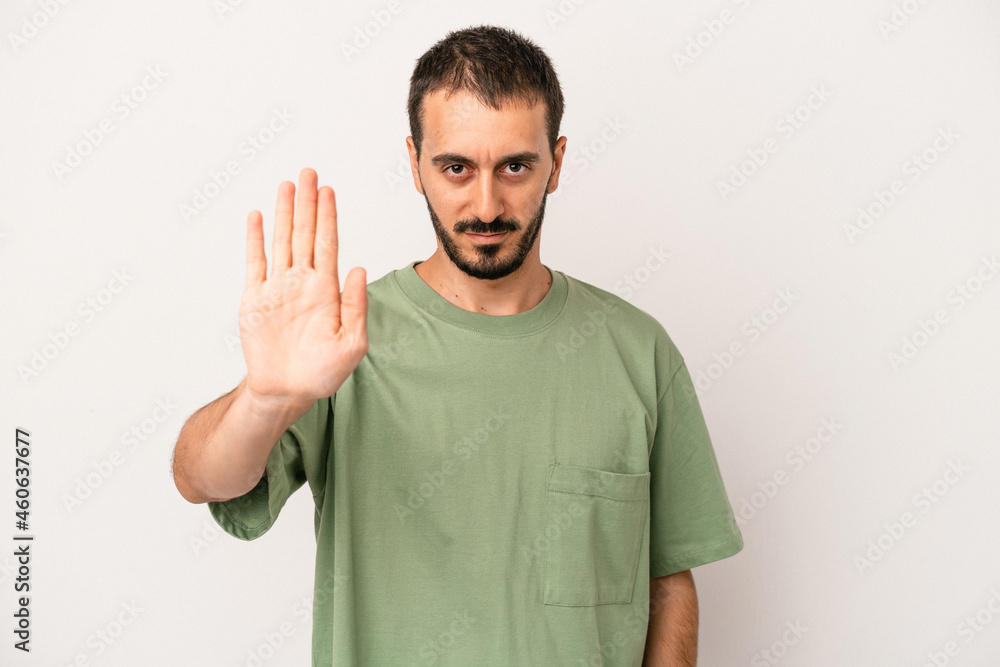 Young caucasian man isolated on white background standing with outstretched hand showing stop sign, preventing you. Young caucasian man isolated on white background standing with outstretched hand showing stop sign, preventing you.