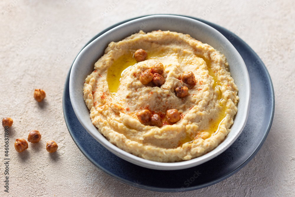 chickpea hummus in a ceramic bowl on beige background. Mediterranean popular snack of chickpeas and tahini. close-up chickpea hummus in a ceramic bowl on beige background. Mediterranean popular snack of chickpeas and tahini. close-up