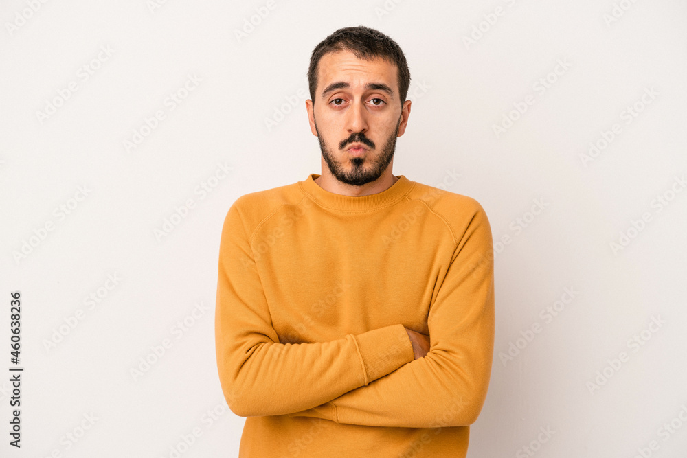 Obraz premium Young caucasian man isolated on white background blows cheeks, has tired expression. Facial expression concept.
