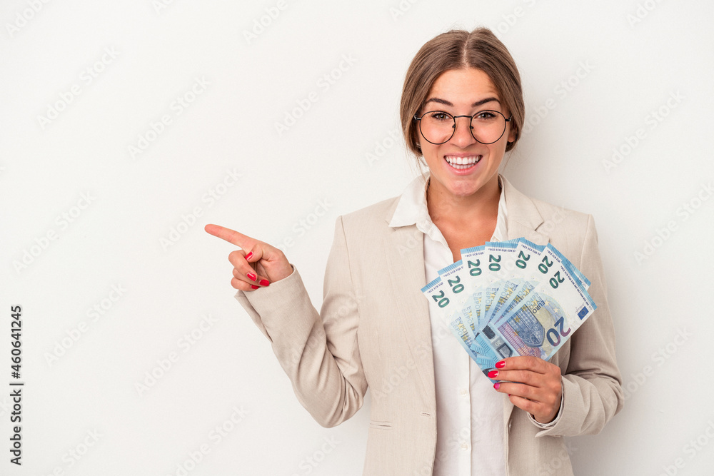 Young Russian business woman holding banknotes isolated on white background smiling and pointing aside, showing something at blank space. Young Russian business woman holding banknotes isolated on white background smiling and pointing aside, showing something at blank space.