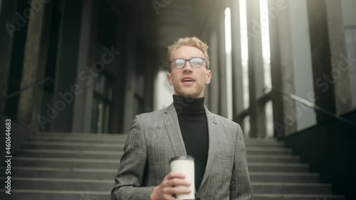 Close-up portrait of nice-looking handsome young businessman with cup of coffee. Attractive office worker. Successful people. High quality 4k footage
