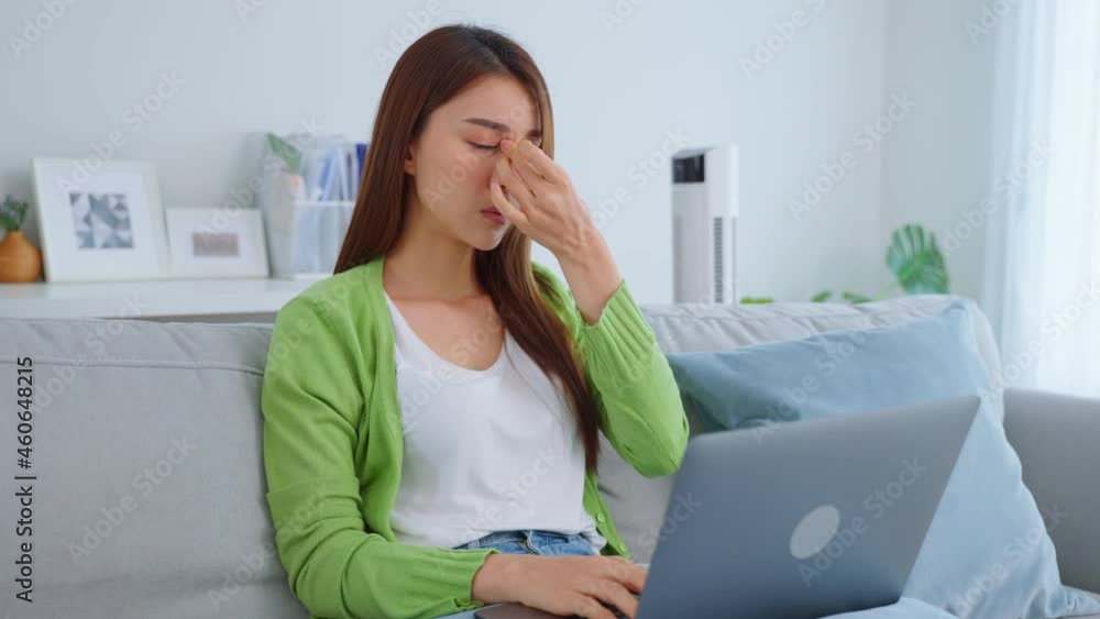 Exhausted Asian business woman hurt eye while using laptop computer. Exhausted Asian business woman hurt eye while using laptop computer.