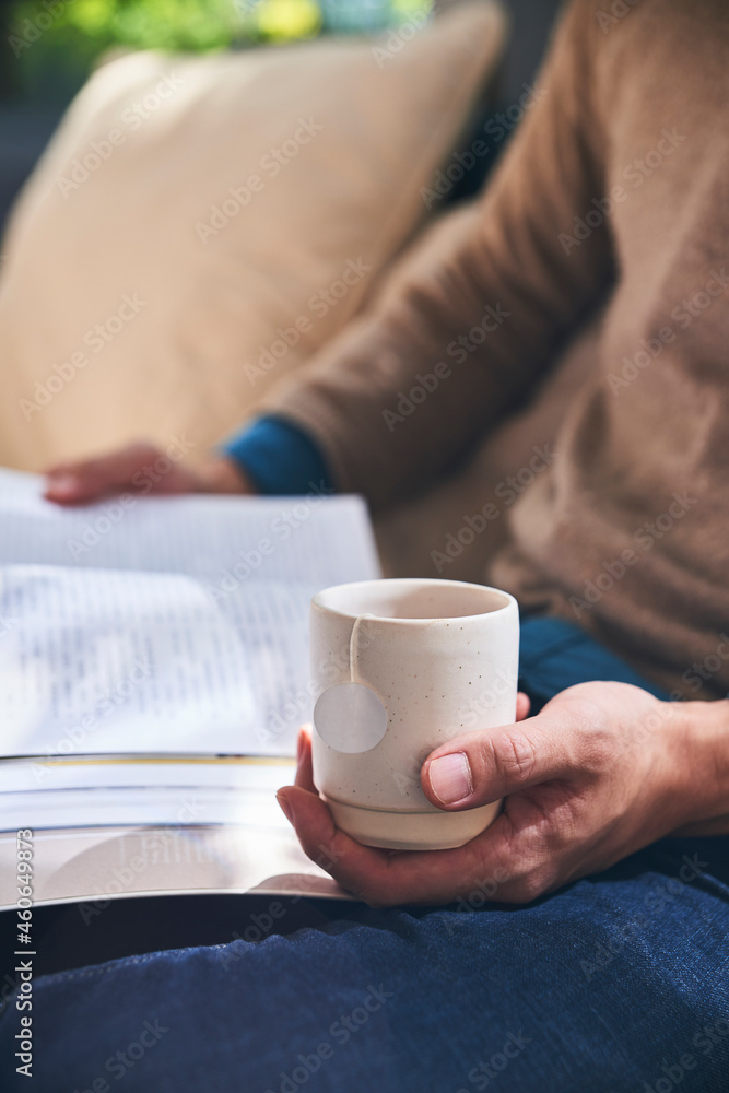 Enjoying tea time reading a book while holding tea cup Enjoying tea time reading a book while holding tea cup