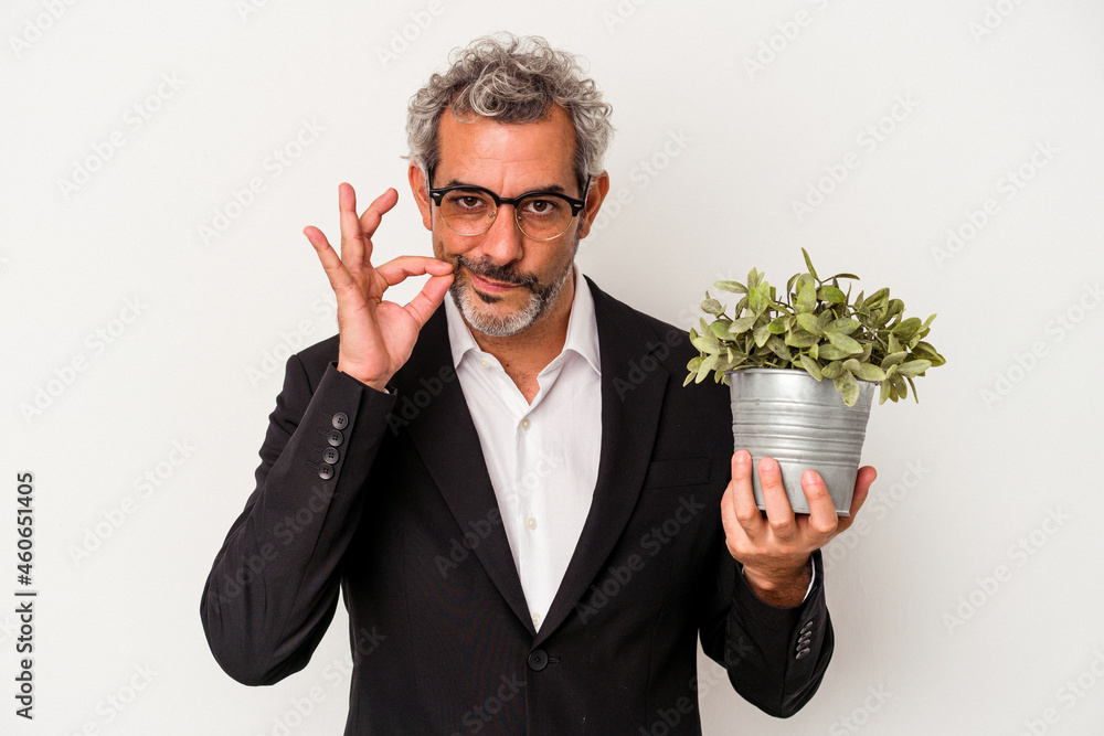 Middle age business man holding a plant isolated on white background with fingers on lips keeping a secret. Middle age business man holding a plant isolated on white background with fingers on lips keeping a secret.