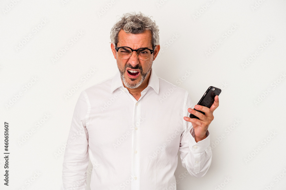 Middle age caucasian business man holding a mobile phone isolated on white background screaming very angry and aggressive. Middle age caucasian business man holding a mobile phone isolated on white background screaming very angry and aggressive.
