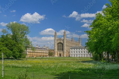 Facade of Gothic style King's College Chapel next to the Gibbs' Building among fields and trees in the University of Cambridge England