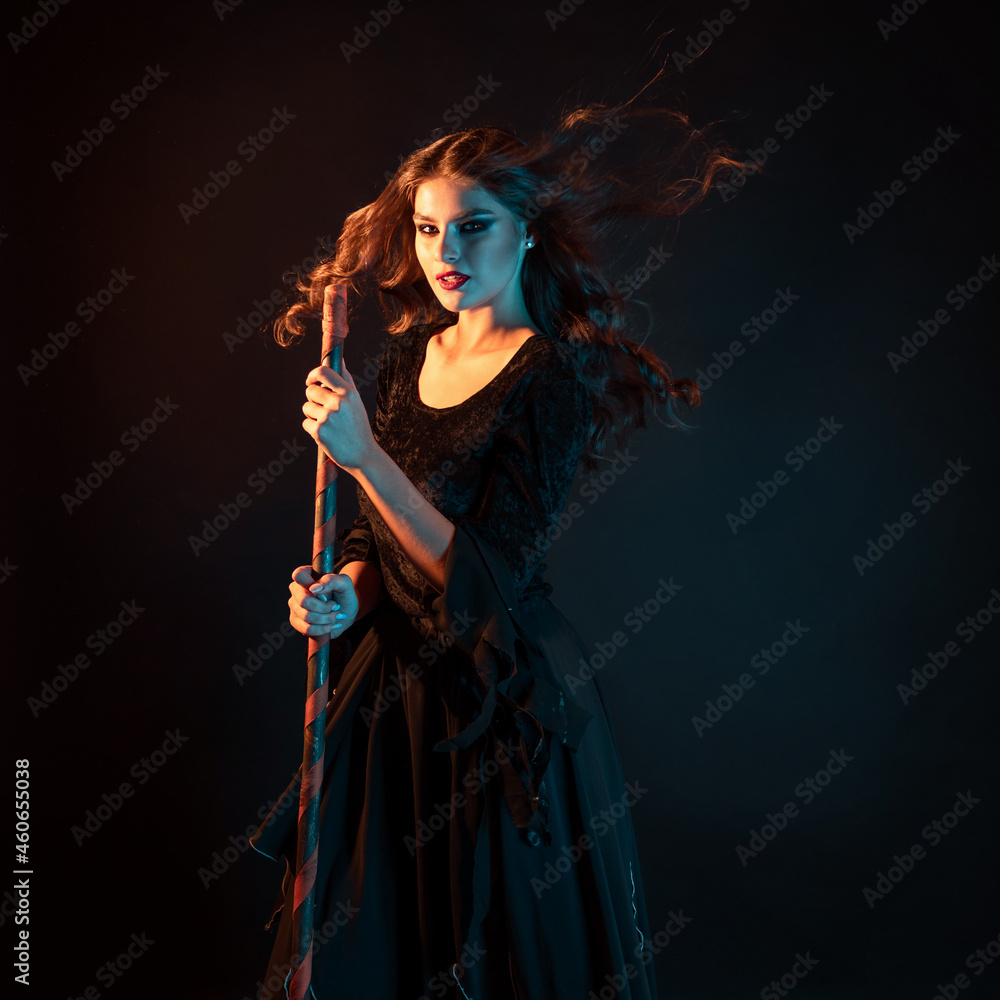 young witch is rushing to the sabbath. young beautiful brunette in a witch dress
