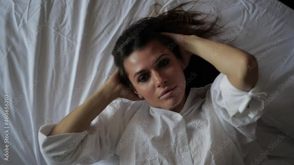 sexy brunette girl lies on a white bed, plays with her hair and looks straight into the camera. High quality FullHD footage sexy brunette girl lies on a white bed, plays with her hair and looks straight into the camera. High quality FullHD footage