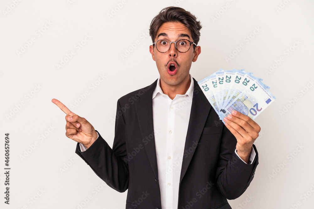 Young mixed race business man holding bills isolated on white background pointing to the side Young mixed race business man holding bills isolated on white background pointing to the side