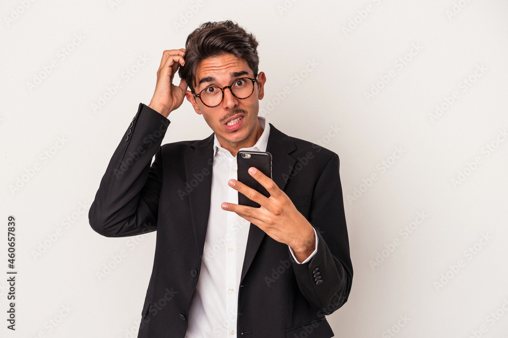 Young mixed race business man holding mobile phone isolated on white background being shocked, she has remembered important meeting. Young mixed race business man holding mobile phone isolated on white background being shocked, she has remembered important meeting.