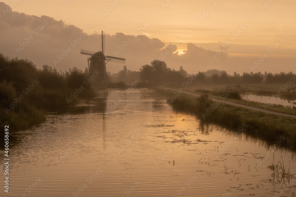 Calm and foggy golden sunrise morning on the Hazerswouder-Dorp windmill,  Rietveldse, Netherlands.