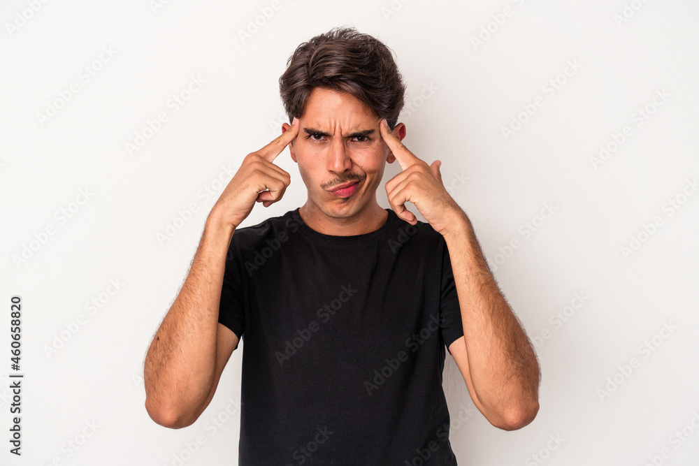 Young mixed race man isolated on white background focused on a task, keeping forefingers pointing head. Young mixed race man isolated on white background focused on a task, keeping forefingers pointing head.