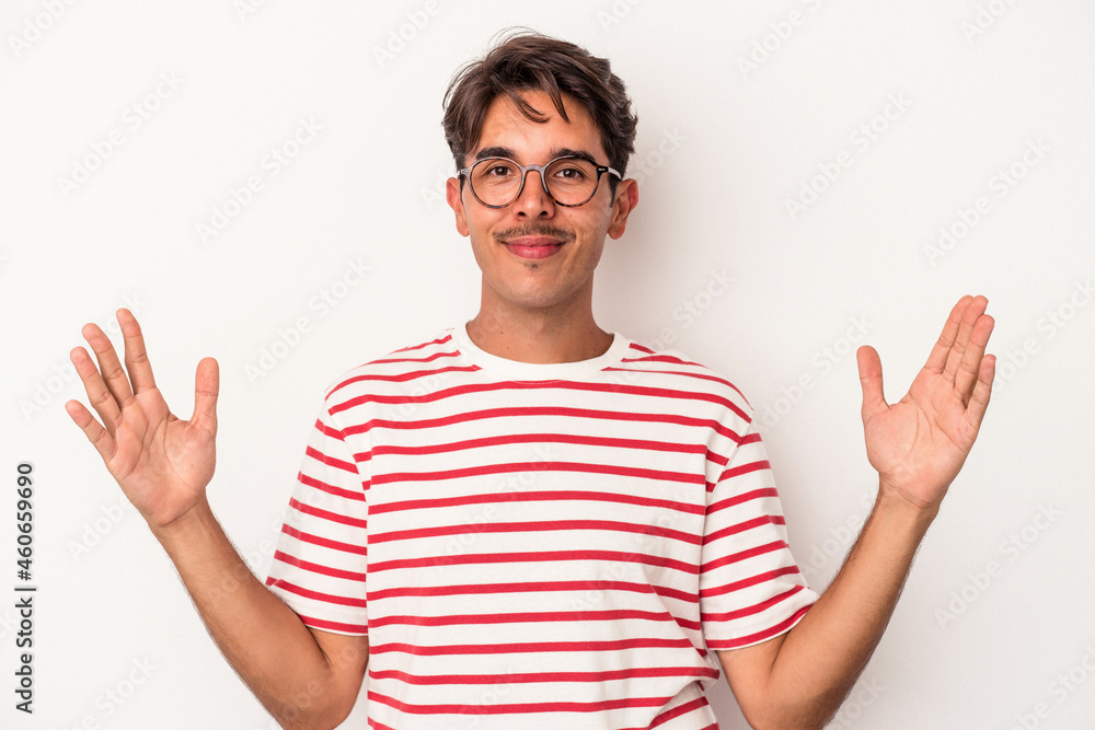 Young mixed race man isolated on white background holding something little with forefingers, smiling and confident. Young mixed race man isolated on white background holding something little with forefingers, smiling and confident.