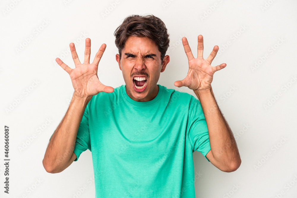 Young mixed race man isolated on white background showing claws imitating a cat, aggressive gesture. Young mixed race man isolated on white background showing claws imitating a cat, aggressive gesture.