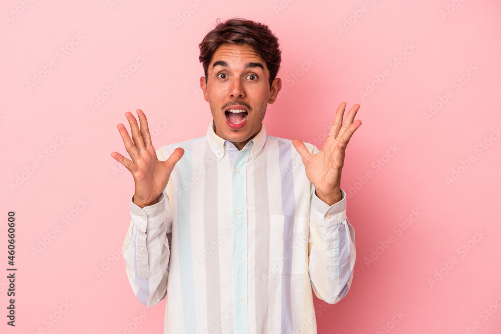 Young mixed race man isolated on white background celebrating a victory or success, he is surprised and shocked. Young mixed race man isolated on white background celebrating a victory or success, he is surprised and shocked.