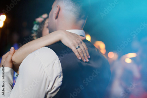 romantic monent and feelings. wedding day at evening close up. bride with wedding ring and groom hugging at dark background. woman and man hugging  and kissing closeup at night. romantic date concept photo
