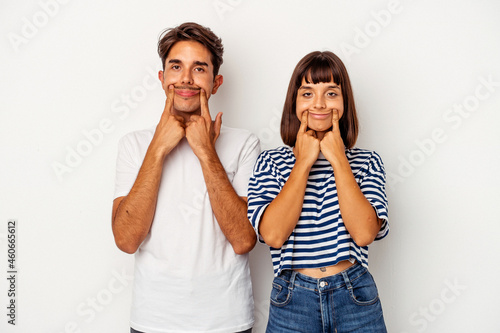 Young mixed race couple isolated on white background doubting between two options.