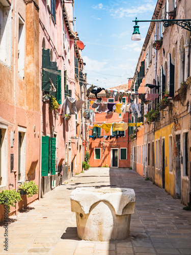 Idyllic traditional italian street in Venice during summer with laundry and clothes in between the houses.