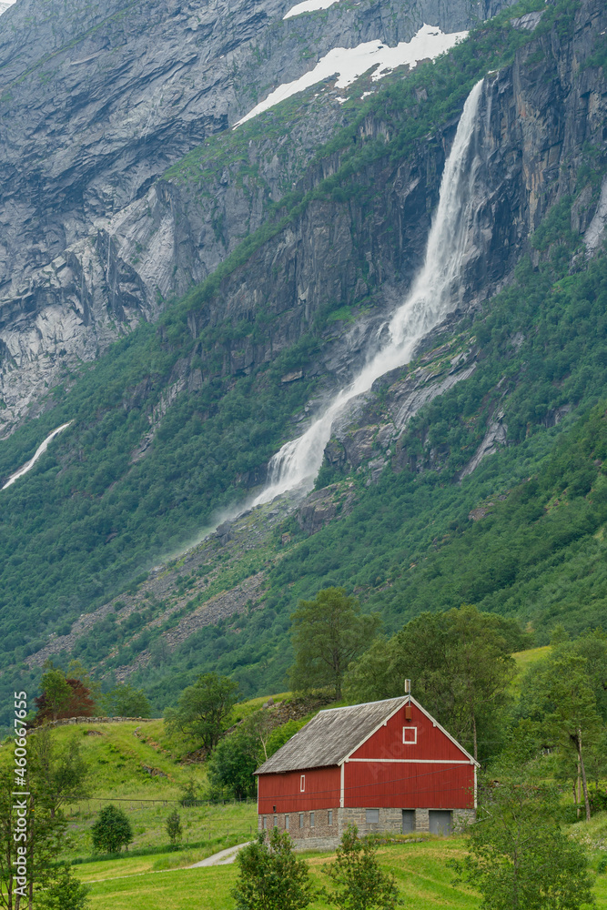 Red farm house below the mountain and waterfall. Red farm house below the mountain and waterfall.
