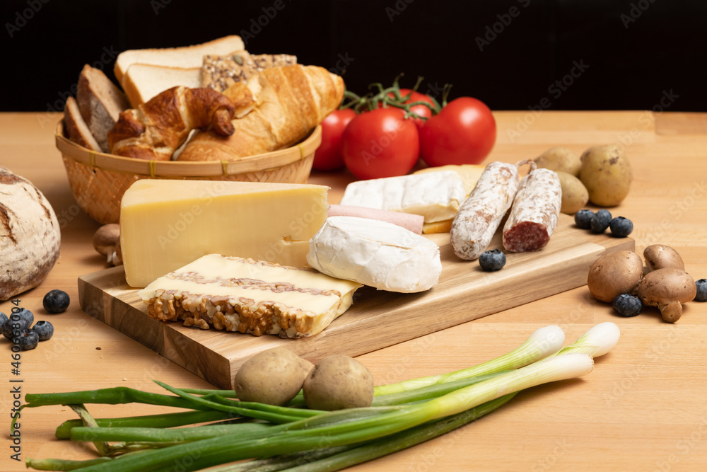 Tisch mit Holz und Käse Holzplatte, mit frischem Brot, Tomaten und Kartoffeln. Traditionelle Brotzeit für gesunde Ernährung. Tisch mit Holz und Käse Holzplatte, mit frischem Brot, Tomaten und Kartoffeln. Traditionelle Brotzeit für gesunde Ernährung.