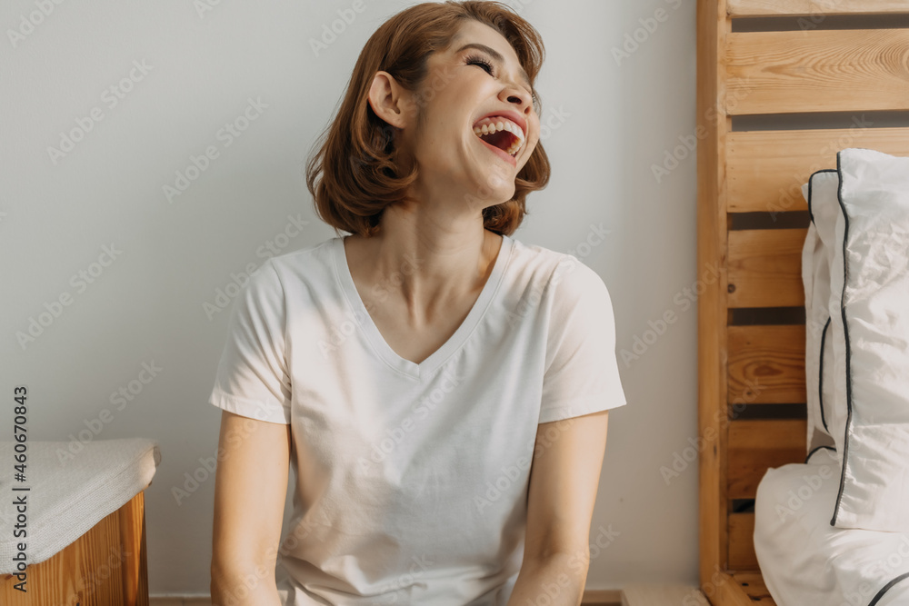 Cool looks of an Asian woman in a t-shirt and jeans relax in her apartment room.