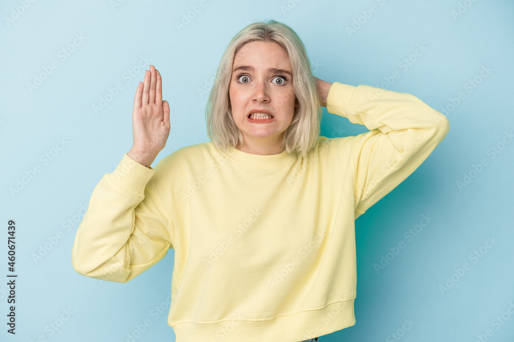 Young caucasian woman isolated on blue background screaming with rage. Young caucasian woman isolated on blue background screaming with rage.