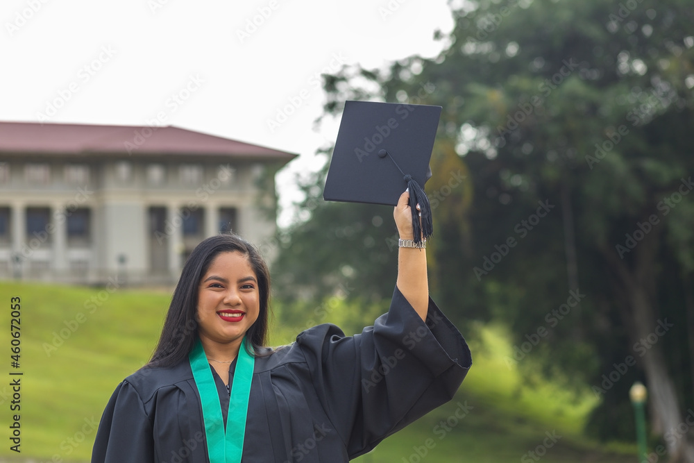 graduate holding mortarboard with hand graduate holding mortarboard with hand