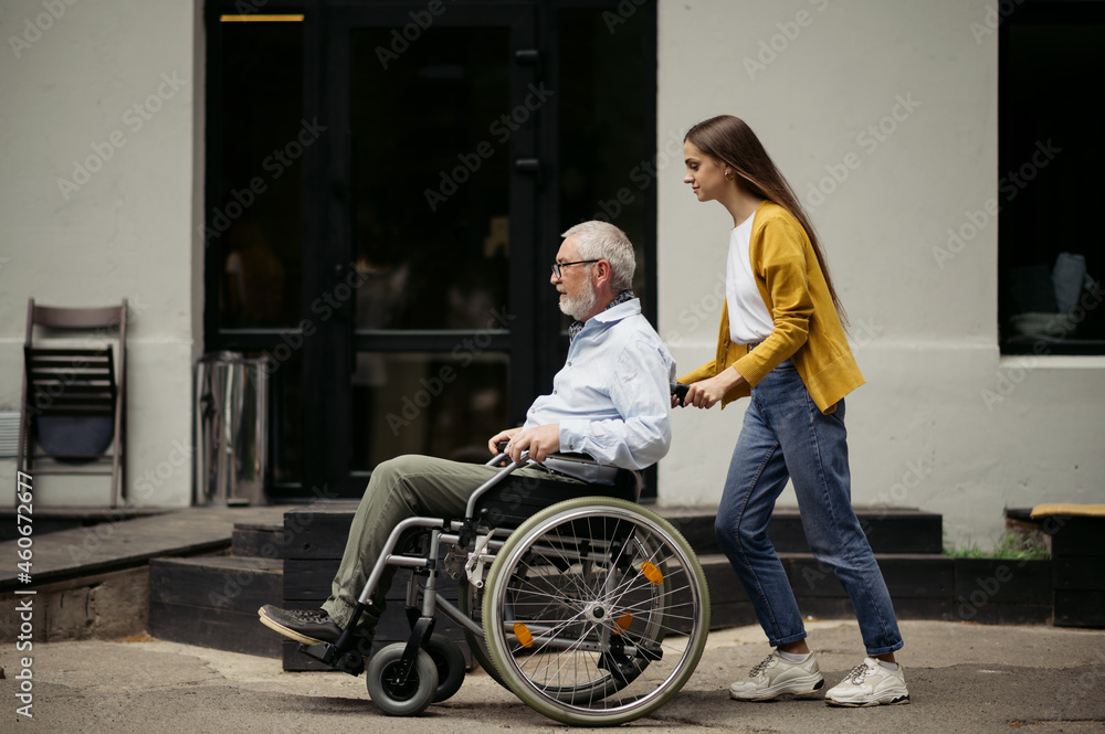 Daughter and disabled father go for a walk Daughter and disabled father go for a walk
