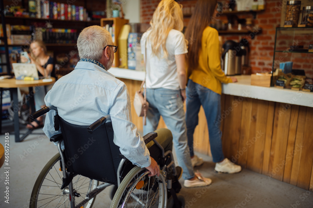 Adult disabled man in wheelchair, queue at a cafe Adult disabled man in wheelchair, queue at a cafe