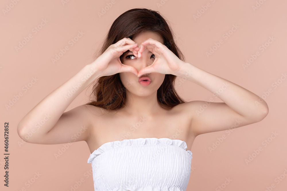 Fototapeta premium Beautiful asian woman long hair smile with clean and fresh skin happiness and cheerful with hands giving heart signal, Facial treatment, Beauty and cosmetics concept.