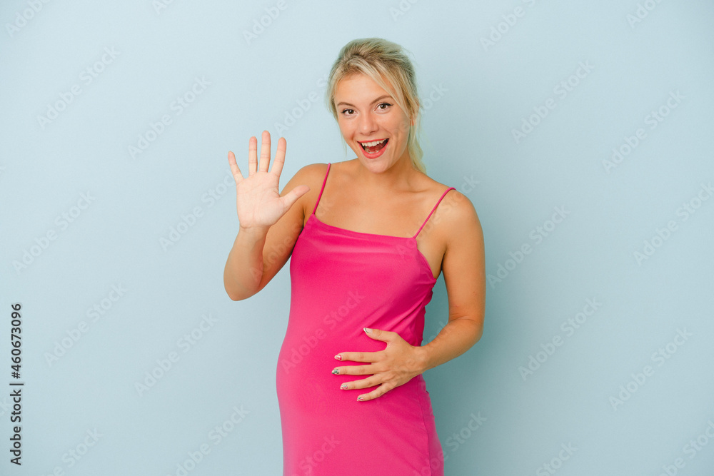 Young Russian woman pregnant isolated on blue background smiling cheerful showing number five with fingers.