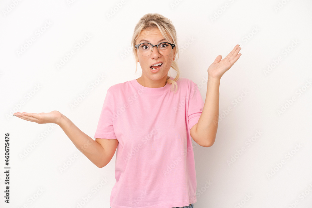 Young Russian woman isolated on white background holds copy space on a palm, keep hand over cheek. Amazed and delighted. Young Russian woman isolated on white background holds copy space on a palm, keep hand over cheek. Amazed and delighted.