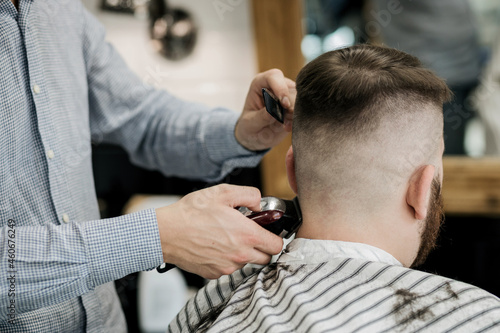 barber shaves the back of the client's