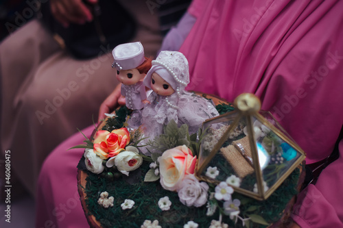 A cute wedding dowry with a Muslim bridal doll on it. The dowry or wedding gift (mahar pernikahan) is the property given by the bridegroom to the bride at the wedding. photo
