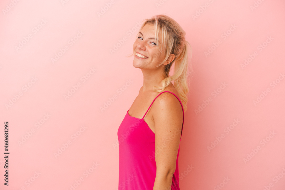 Young Russian woman isolated on pink background confident keeping hands on hips.